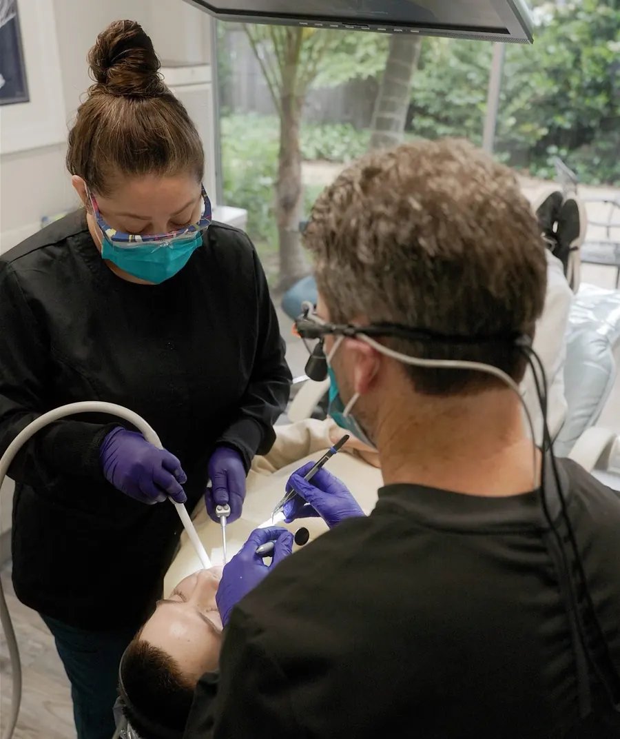 Dr. Miller and a dental assistant treating a patient at Dentistry in Paradise.